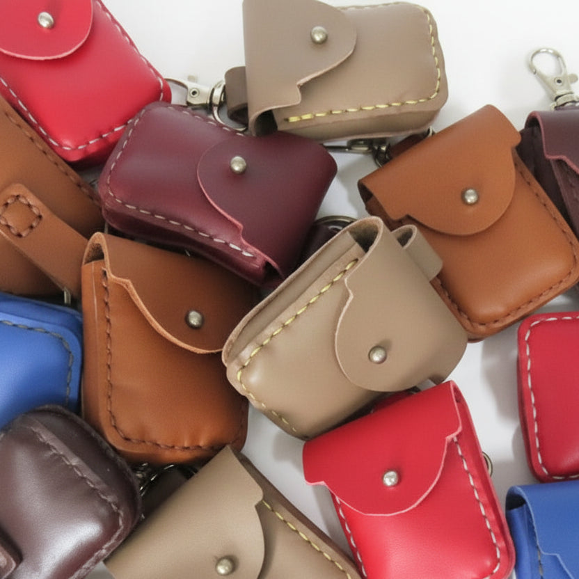 Collection of small leather pouches in various colors on a white background