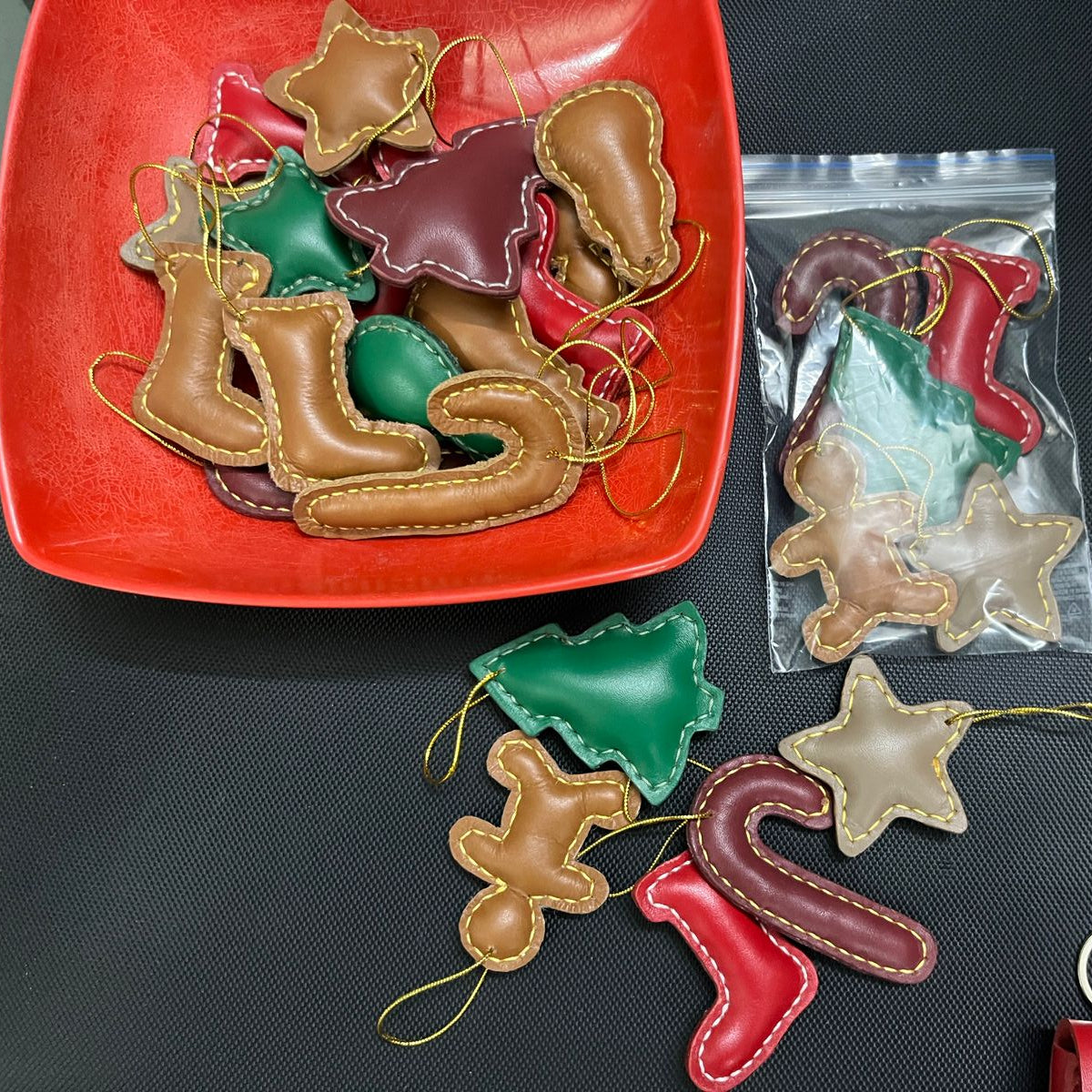 Assorted Christmas ornaments including boots, stars, and candy canes on a red plate.