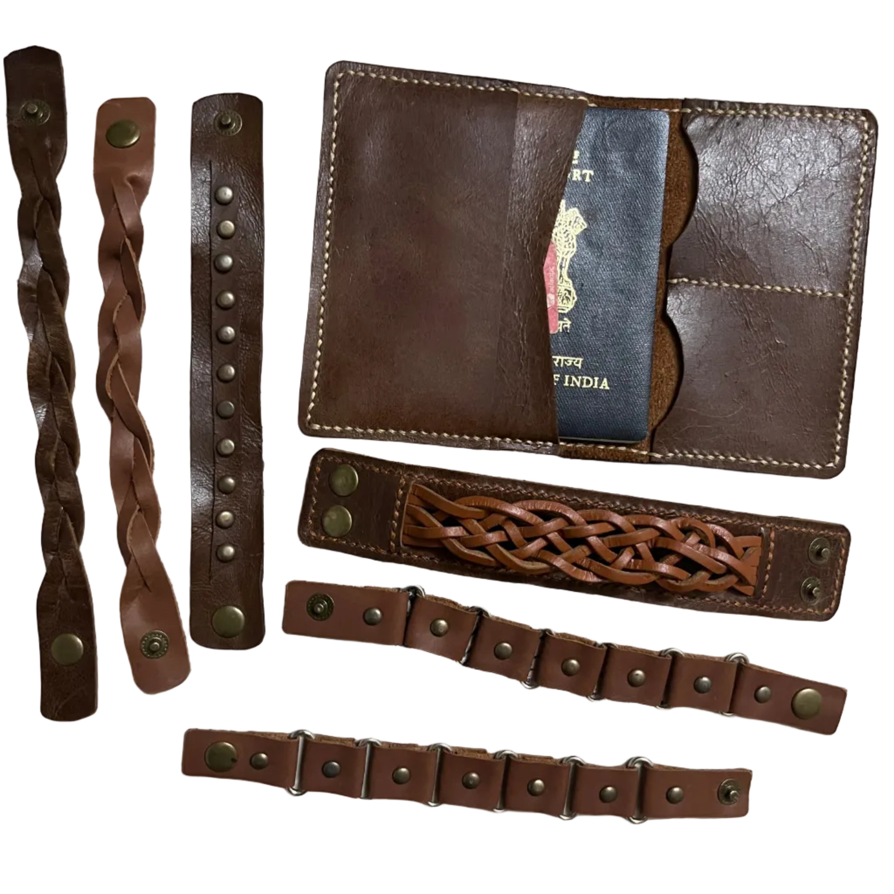 Set of brown leather accessories including a wallet and multiple straps on a patterned fabric background.