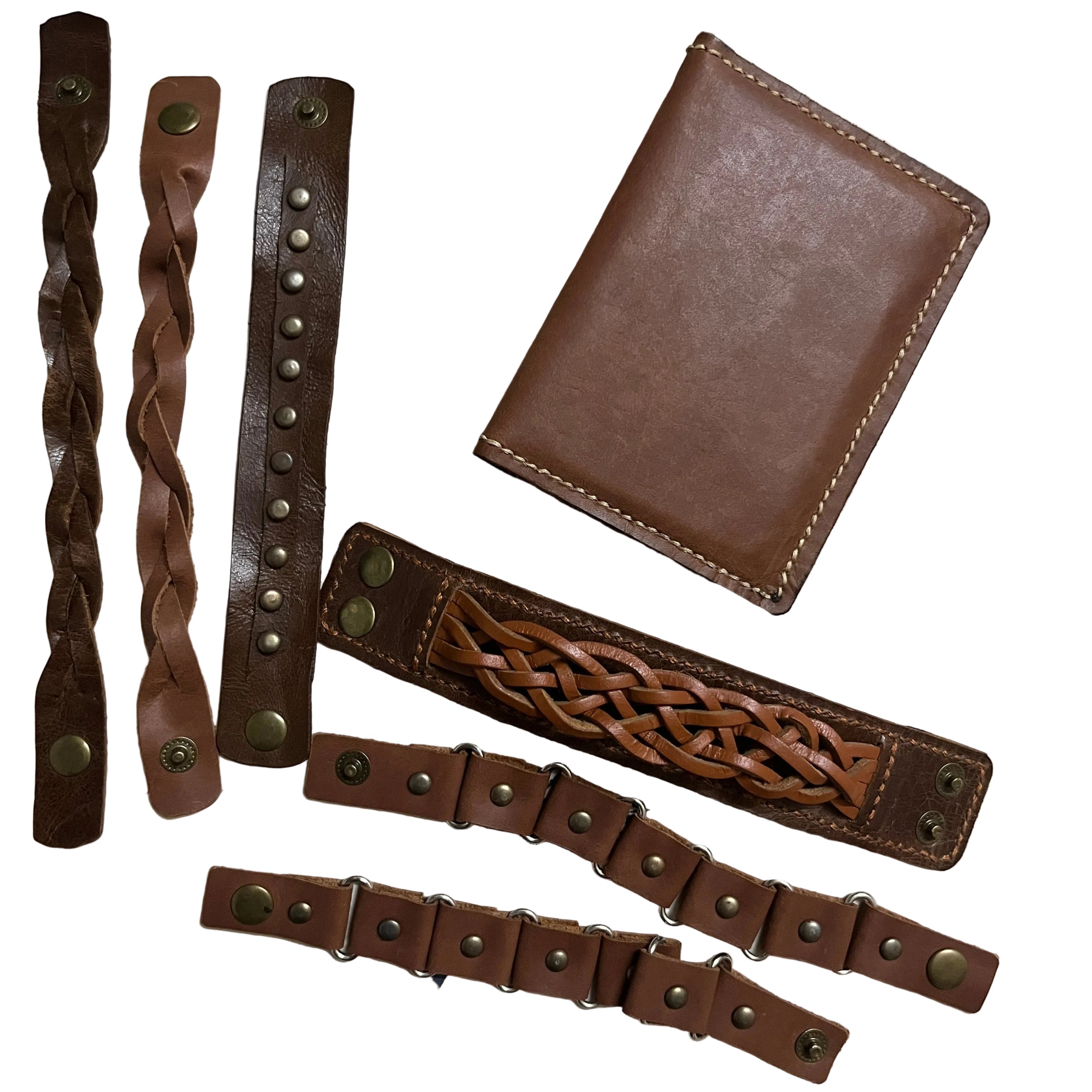 Brown leather wallet and multiple leather straps on a patterned fabric background
