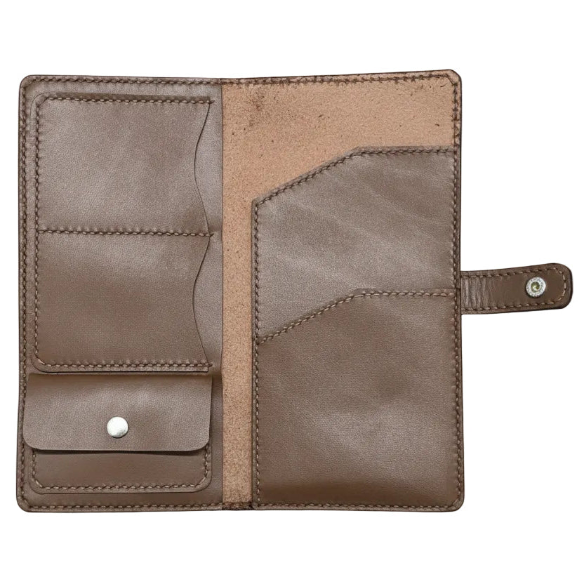 Brown leather wallet on a green cutting mat with grid lines