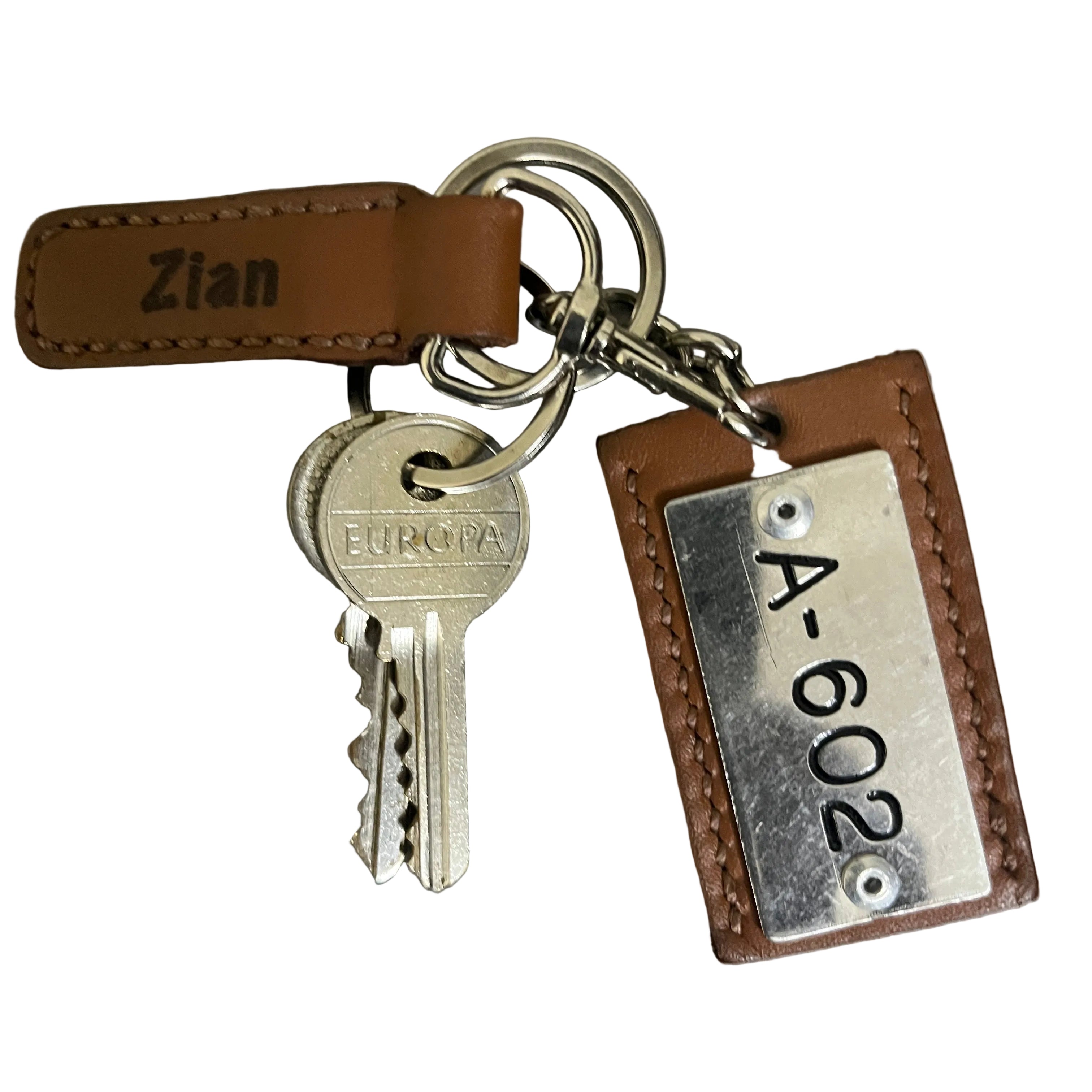 Keychain with key and leather tag on a gray background
