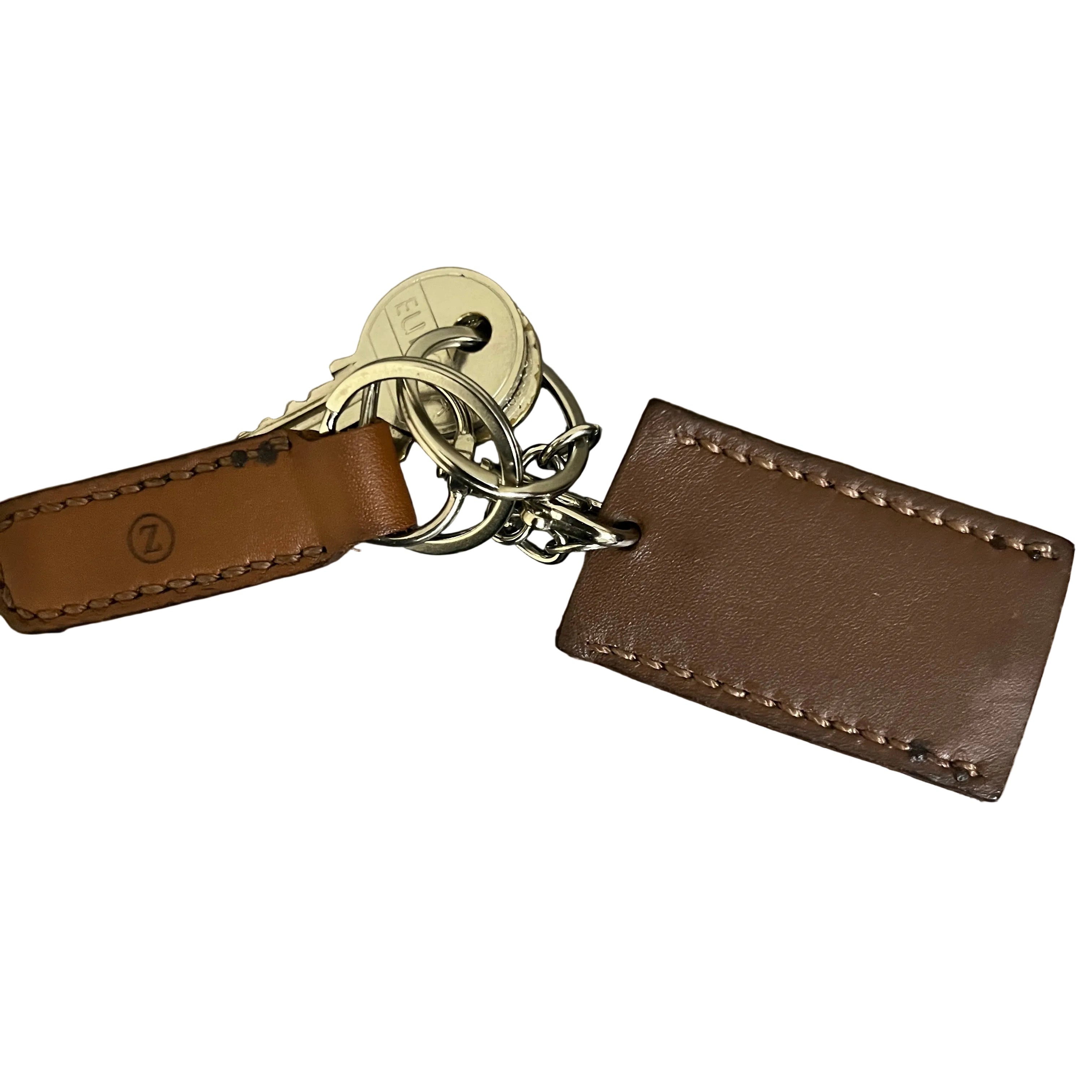 Brown leather keychain with keys on a metallic surface