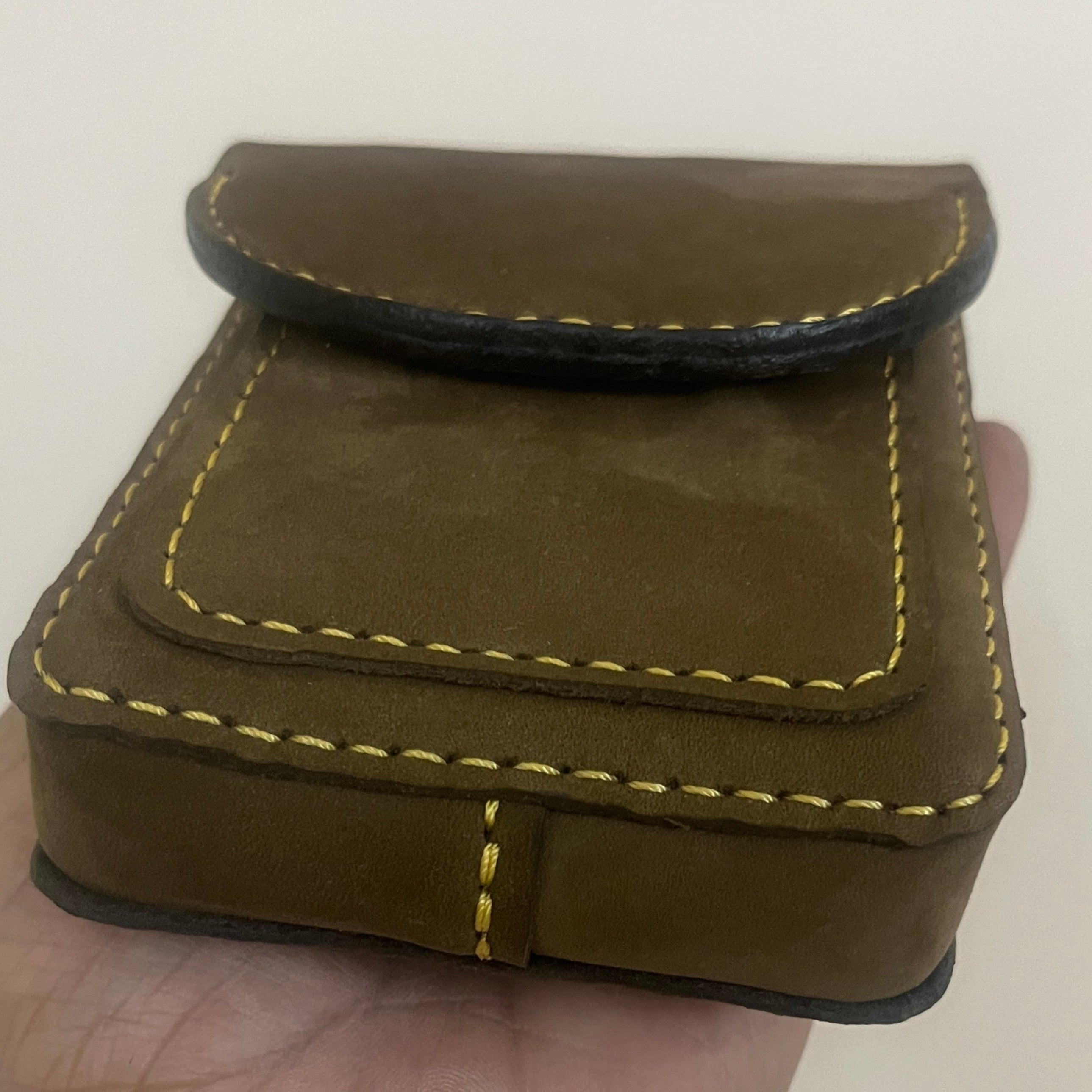 Brown leather wrist support worn on a wrist against a plain background