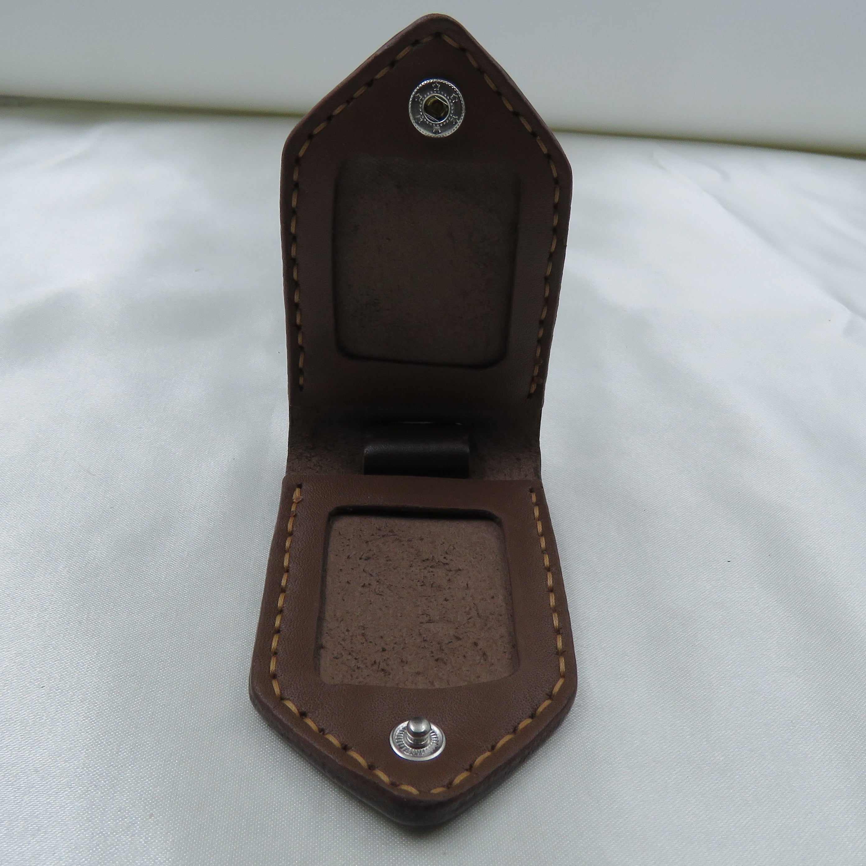 Brown leather key holder on a white surface