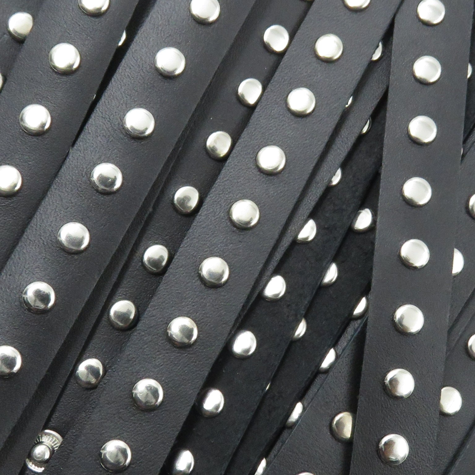 Close-up of black leather straps with silver studs