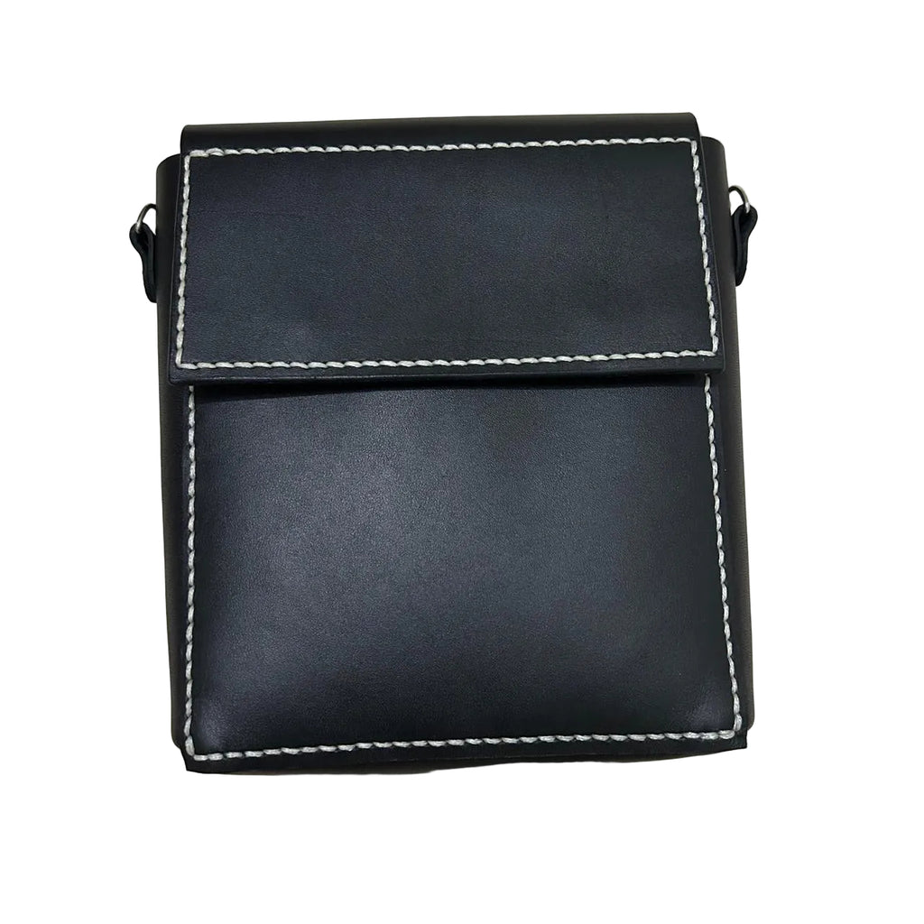 Black leather pouch with white stitching on a beige background