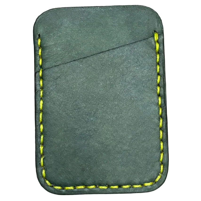 Green leather cardholder with yellow stitching on a wooden surface