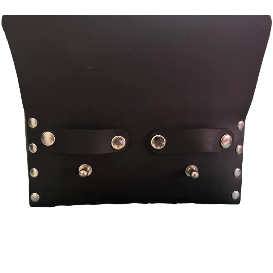 Black leather pouch with silver studs on a green cutting mat.