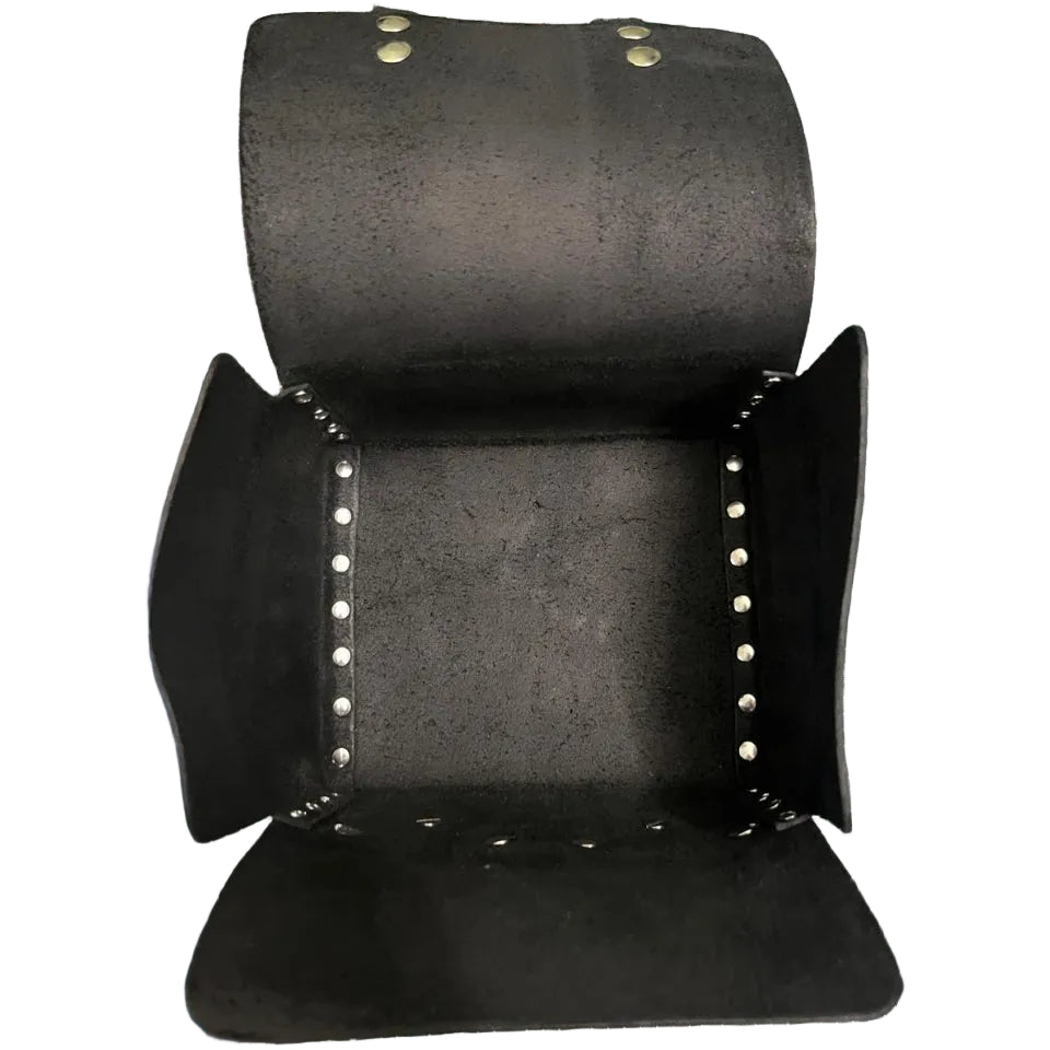 Black leather arm guard with studs on a green cutting mat