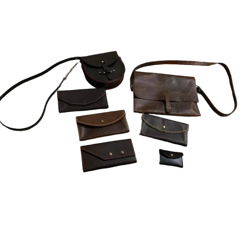 Collection of black handbags and wallets on a floral-patterned surface